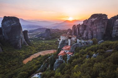 Günbatımında Meteora vadisi ve tarihi kanyonu, Kalambaka, Yunanistan, gölgeler, çarpık yol, köprü ve dağların nefes kesen manzarası.