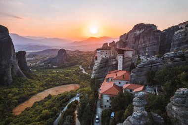 Günbatımında Meteora vadisi ve tarihi kanyonu, Kalambaka, Yunanistan, gölgeler, çarpık yol, köprü ve dağların nefes kesen manzarası.