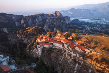 Günbatımında Meteora vadisi ve tarihi kanyonu, Kalambaka, Yunanistan, gölgeler, çarpık yol, köprü ve dağların nefes kesen manzarası.
