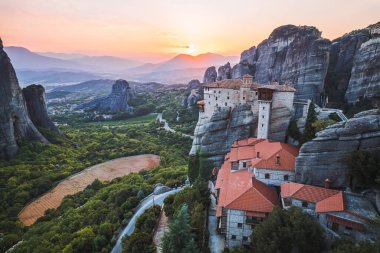 Günbatımında Meteora vadisi ve tarihi kanyonu, Kalambaka, Yunanistan, gölgeler, çarpık yol, köprü ve dağların nefes kesen manzarası.