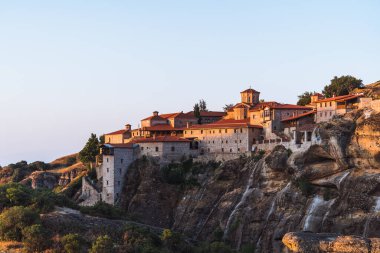 Günbatımında Meteora vadisi ve tarihi kanyonu, Kalambaka, Yunanistan, gölgeler, çarpık yol, köprü ve dağların nefes kesen manzarası.