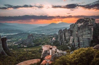 Günbatımında Meteora vadisi ve tarihi kanyonu, Kalambaka, Yunanistan, gölgeler, çarpık yol, köprü ve dağların nefes kesen manzarası.