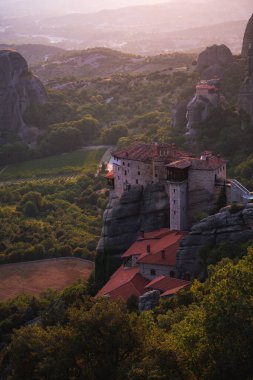 Günbatımında Meteora vadisi ve tarihi kanyonu, Kalambaka, Yunanistan, gölgeler, çarpık yol, köprü ve dağların nefes kesen manzarası.
