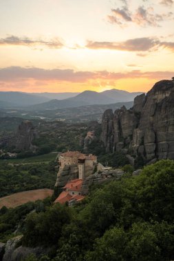 Günbatımında Meteora vadisi ve tarihi kanyonu, Kalambaka, Yunanistan, gölgeler, çarpık yol, köprü ve dağların nefes kesen manzarası.
