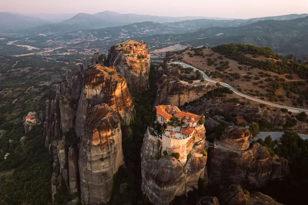 Günbatımında Meteora vadisi ve tarihi kanyonu, Kalambaka, Yunanistan, gölgeler, çarpık yol, köprü ve dağların nefes kesen manzarası.