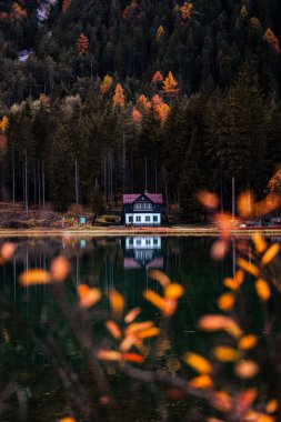 Toblacher See 'nin Sonbahar Sonbaharı Renkleri, Dolomitler İtalya' sında bir evi ve yansımaları olan Lago di Dobbiaco. Yüksek kalite fotoğraf