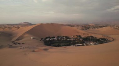 Huacachina, Ica, Peru, Güney Amerika 'da çölün, kum tepelerinin, mitinglerin ve böceklerin 4K hava aracı içeriği. Yüksek kalite 4k görüntü