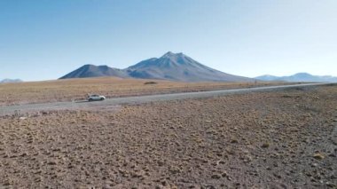 San Pedro de Atacama Şili 'deki volkanik dağların önünde araba sürüyor. Yüksek kalite fotoğraf