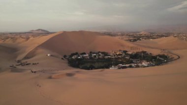 Huacachina, Ica, Peru, Güney Amerika 'da çölün, kum tepelerinin, mitinglerin ve böceklerin 4K hava aracı içeriği. Yüksek kalite 4k görüntü