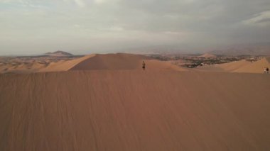 Huacachina, Ica, Peru, Güney Amerika 'da çölün, kum tepelerinin, mitinglerin ve böceklerin 4K hava aracı içeriği. Yüksek kalite 4k görüntü