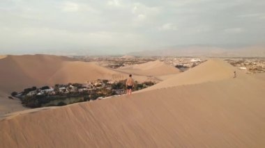 Huacachina, Ica, Peru, Güney Amerika 'da çölün, kum tepelerinin, mitinglerin ve böceklerin 4K hava aracı içeriği. Yüksek kalite 4k görüntü