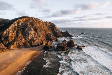 Güneş batarken Portekiz 'de Praia da Ursa' nın hava aracı fotoğrafı. Yüksek kalite 4k görüntü