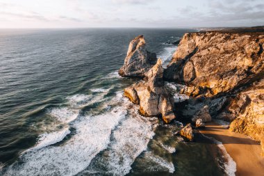 Güneş batarken Portekiz 'de Praia da Ursa' nın hava aracı fotoğrafı. Yüksek kalite 4k görüntü