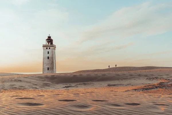 Minimalistic photo of people at sunset Rubjerg Knude Lighthouse Denmark. High quality photo