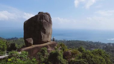 Tayland, Ko Samui 'de bir kişiyle çakışan bir taşın tropik dron görüntüleri. Yüksek kaliteli FullHD görüntüler