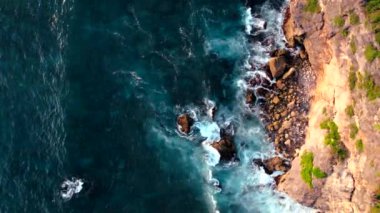 Endonezya, Bali 'deki Uluwatu Tapınağı yakınlarında okyanusa düşen dalgaların videosu. Yüksek kaliteli video