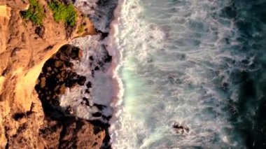 Endonezya, Bali 'deki Uluwatu Tapınağı yakınlarında okyanusa düşen dalgaların videosu. Yüksek kaliteli video
