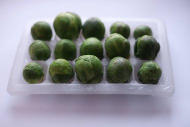 Yeşil arka planda, şeffaf bir kabın içinde sulu yeşil lahana ve su damlaları var. dükkan etiketleri giriş pankartları tarifleri için