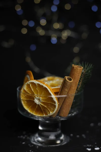 Sötét Háttérrel Egy Átlátszó Üveg Szilveszteri Díszítéssel Narancsból Fahéjas Füzérből — Stock Fotó