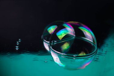 Ayna yüzeyinde su damlaları olan parlak gökkuşağı renkli, şeffaf, şeffaf, parlak, parlak dokular. Kartvizit etiketleri için başlık işaretleri için el ilanları