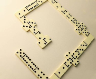 Tüm aile ve domino oyuncuları için mantık oyunu. Açık renkli domino taşlarının üzerinde siyah noktalar var.