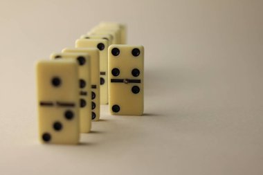 Tüm aile ve domino oyuncuları için mantık oyunu. Açık renkli domino taşlarının üzerinde siyah noktalar var.