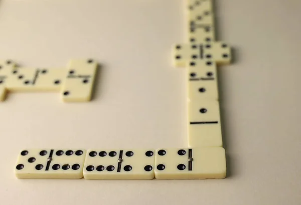board logic game for the whole family and friends of dominoes. light-colored dominoes with black dots on a light and mirror background