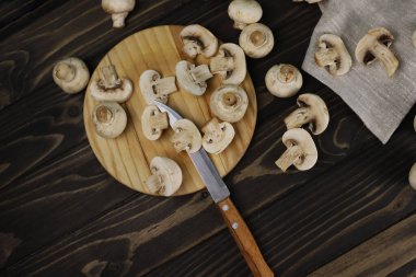 Karanlık bir mutfakta, bıçak ve biberliğin yanında taze kokulu şampiyon mantarları. etiketler için açılış ekranı menü pankartları mağaza işaretleri