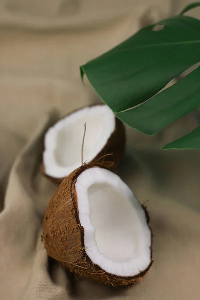 热带成熟椰子的一半 白色的肉和绿色薄荷叶的米色面料 作横幅 明信片 饭盒等用途 — 图库照片