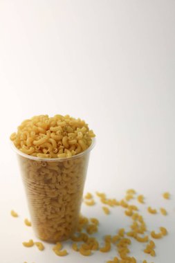 Beyaz arka planda bardakta buğday makarnası. pankartlar, reklamlar, sıçrama ekranları, etiketler ve daha fazlası için