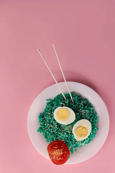 ピンクの背景に白丸のキッチンプレートにゴマと卵とトマトが半分入ったグリーンパスタ 広告メニュー バナー チラシ ラベル 名刺などに — ストック写真