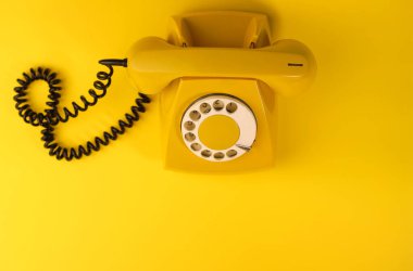 Parlak sarı bir arka planda sarı, parlak bir retro telefon. pankartlar, reklamlar, el ilanları, ekran koruyucular, kapaklar, davetiye kartları vs..