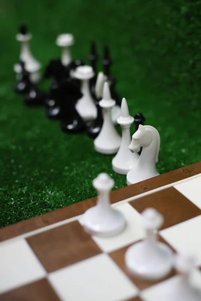 Λευκά Και Μαύρα Κομμάτια Σκάκι Σταθεί Μια Σκακιέρα Ένα Πράσινο — Φωτογραφία Αρχείου