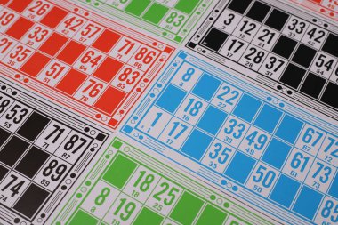 Piyango oyunu. Gri arkaplanda, sayılı çok renkli kartlar ve sayılı ahşap variller var.