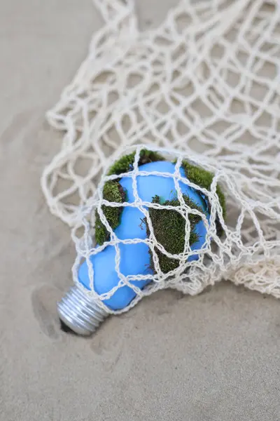 social problems. Earth Day. blue light bulb with green moss entangled in networks