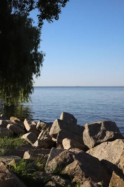Göldeki panorama. Kayalık kıyı ve ufukta deniz manzarası