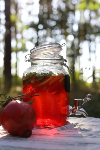 Nane, limon, greyfurt ve nane aromalı ve doğada cam bir kavanozda naneli nar limonata. Yakınlarda bir nar var.