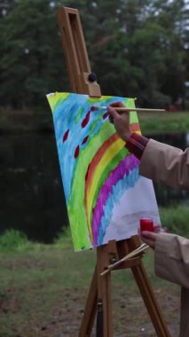 Doğada çizim yapmak. Sanatçı, ormanda tuvale bir resim çizer.