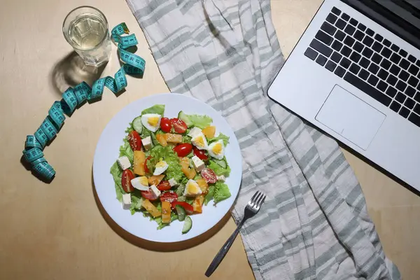 Sağlıklı hafif diyet salatası. Yeşil yapraklı salata, kırmızı ve sarı domates, haşlanmış yumurta, dilimlenmiş peynir ve susam tohumları.