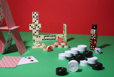 Oyunlar. Kırmızı yeşil arka planda kumar ve masa oyunları. domino, dama, loto, kart ve zar