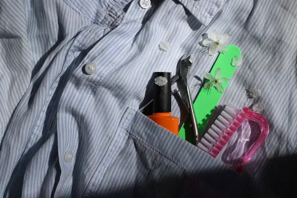 Elbise cebinde manikür aletleri. parlak tırnak törpüsü, bir şişe portakal cilası, tırnak makası, fırça