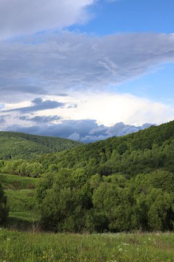 Peyzaj. Yeşil dağlar ve beyaz bulutlu mavi gökyüzü