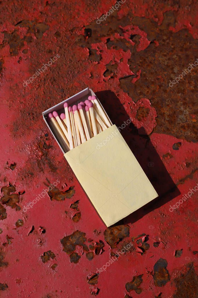Matchbox on red old iron background. matches with pink sulfur