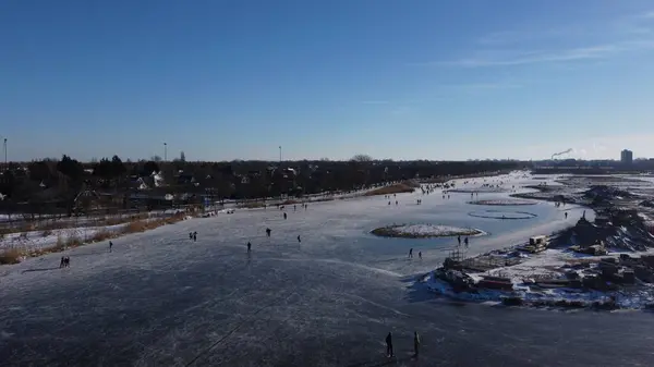 İnsanlar Hollanda 'daki küçük donmuş bir gölde buz pateni yapıyorlar.