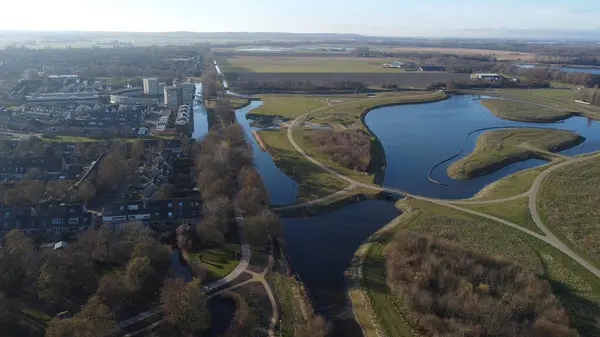 Hollanda 'nın kırsal kesimlerinde ağaçlarla çevrili güzel bir nehir görüntüsü.