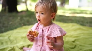 Küçük kız yatak örtüsünde oturmuş krep yiyor. Yüksek kalite 4k görüntü