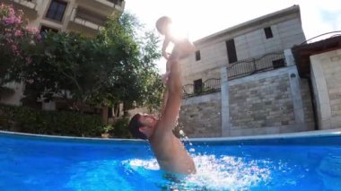 Babam havuzda dururken kollarına küçük bir kız atar. Ağır çekim. Yüksek kalite 4k görüntü