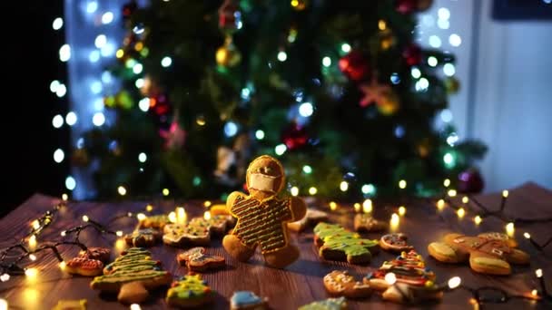 一位姜饼人坐在圣诞树前的一张木制桌子上 桌上装饰着节日的装饰品和装饰品 — 图库视频影像