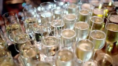 Bir şampanya kadehi koleksiyonu düzgünce masaya istiflenmiş, davetlilerin etkinlikte kutlama içkisinin keyfini çıkarmaları için hazır. Barın vitrinine zarafet katıyor.