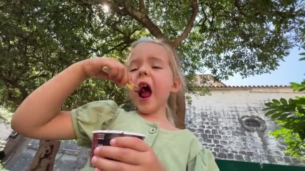 Ett Litet Barn Njuter Lugnt Kopp Glass Med Sked Medan — Stockvideo